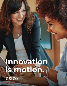 Two businesswomen looking at a tablet while smiling