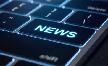 The word 'news' in bright blue as a key on a keyboard