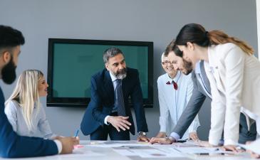Business professionals gathering around a table collaborating
